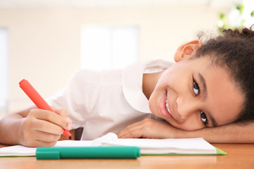 Portrait of beautiful African elementary schoolgirl learning in classroom