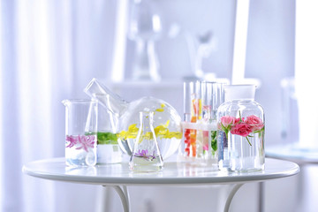 Beautiful composition with perfume samples and flowers on table