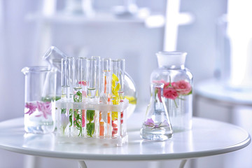 Beautiful composition with perfume samples and flowers on table