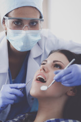 Woman dentist working at her patients teeth