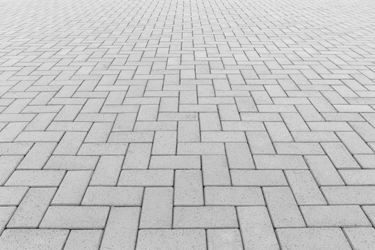Paver brick floor also call brick paving, paving stone or block paving. Manufactured from concrete or stone for road, path, driveway and patio. Empty floor in perspective view for texture background.