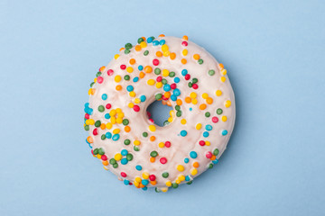 one tasty donut with white glaze isolated on blue background