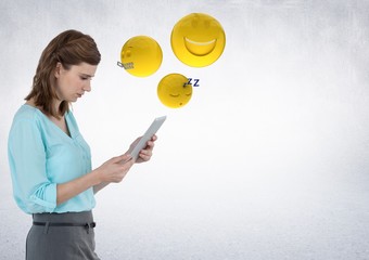 Woman with tablet and emojis with flare against white wall