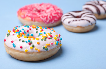 four tasty glazed donuts isolated on blue background