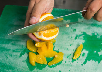 A juicy orange being sliced into segments.