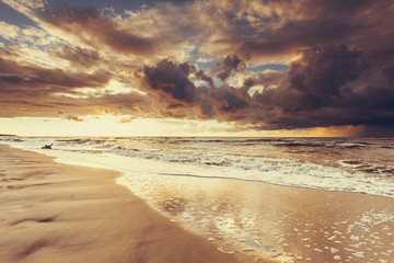 Beatiful sunset with clouds over sea and beach