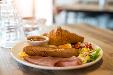 English breakfast with fried eggs, bacon, sausages, beans, toasts and fresh salad