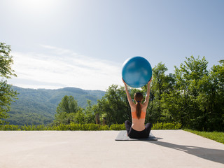 woman doing exercise with pilates ball