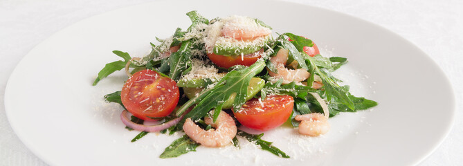 arugula leafs, cherry tomatoes, prawns, avocado, and red onion  salad sprinkled with grated cheese