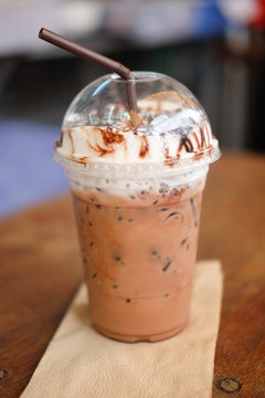 Iced coco or chocolate with straw in plastic cup