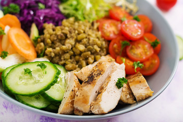 Healthy salad with chicken, tomatoes,  cucumber, lettuce, carrot, celery, red cabbage and  mung bean on light  background. Proper nutrition. Dietary menu.