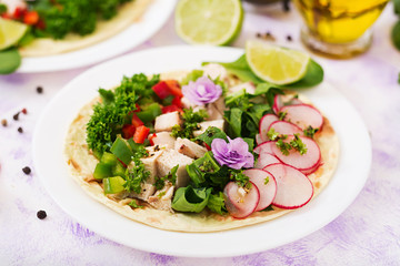 Healthy mexican corn tacos with boiled chicken breast, spinach, radish and paprika.