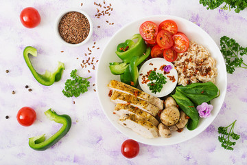 Diet menu. Healthy lifestyle. Oatmeal porridge,  chicken fillet and fresh vegetables - tomatoes, spinach, paprika,  mushrooms and yogurt  on plate. Top view. Flat lay.