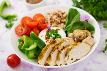 Diet menu. Healthy lifestyle. Oatmeal porridge,  chicken fillet and fresh vegetables - tomatoes, spinach, paprika,  mushrooms and yogurt  on plate.
