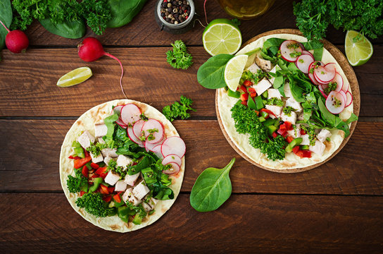 Healthy mexican corn tacos with boiled chicken breast, spinach, radish and paprika. Flat lay. Top view