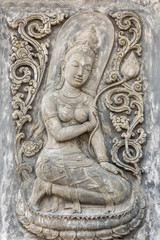 Black and white picture of Buddha statue. Buddha's face on wall