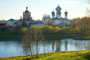 October evening on the Tikhvinka River. View of the temples of the Tikhvin Monastery, Russia