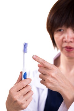 Dentist Pointing At Old Worn Out Toothbrush Bristle