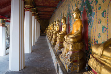 Fototapeta premium Gallery with antique sculptures of the seated Buddha in the Buddhist temple Wat Arun. , Bangkok, Thailand