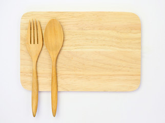 wooden spoon and fork on wooden board against white background