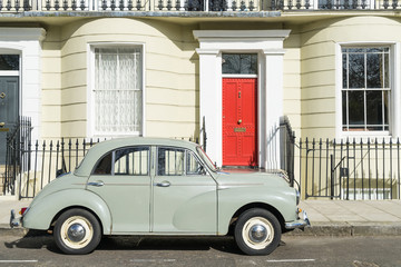 London - March 30: Oldtimer car parked in front of Kensington luxury town house on March 30, 2017.