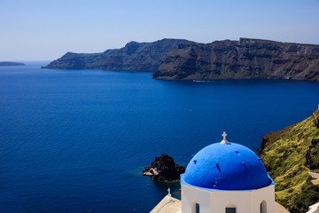 Fototapeta na wymiar White church with blue dome in Santorini, Greece