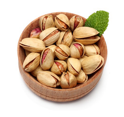 pistachio in wood plate with green leaf isolated on the white background