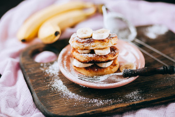Cottage cheese pancakes with banana slices on plate top view