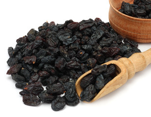 Organic dried Raisins in wood plate isolated on white background