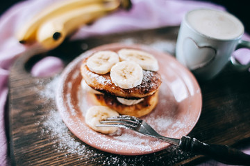 Cottage cheese pancakes with banana slices on plate top view