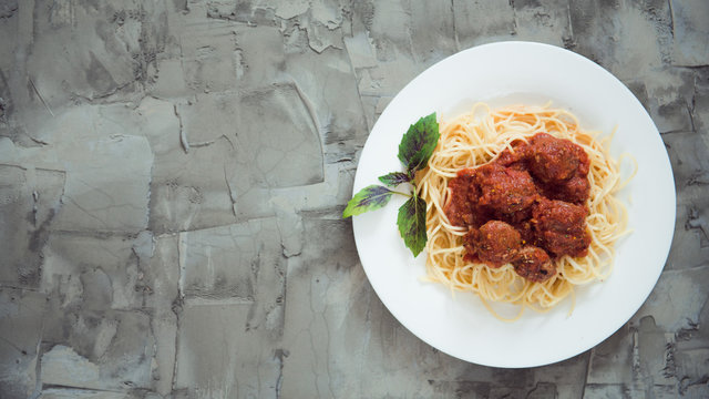 spaghetti and meatballs on a concrete background. Top view. Copy space