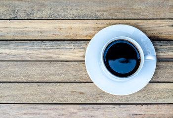 Cup of coffee on wooden table, top view