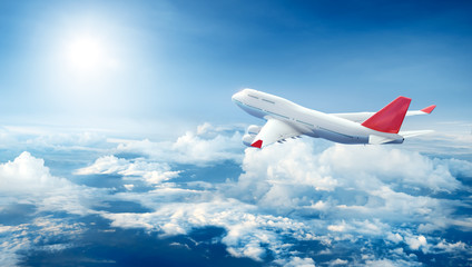 Naklejka premium Samolot latający nad chmurami
