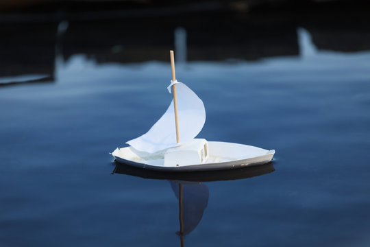 White Toy Boat At A Pier In A Pond In Summer