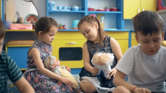 Four children are playing on the floor with toys