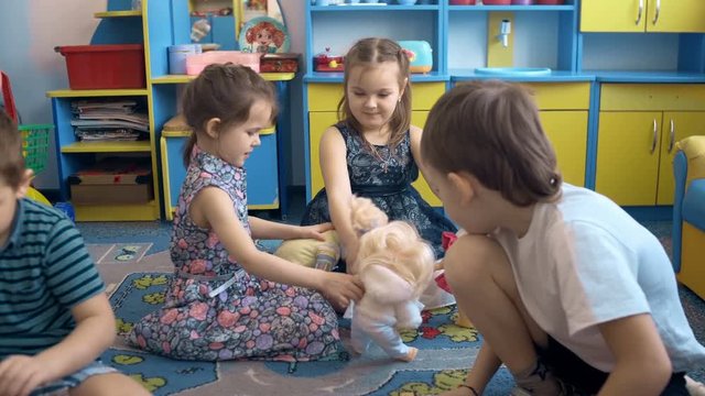 Four children are playing on the floor with toys