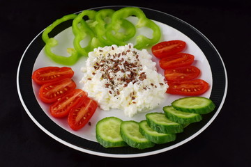 Easy breakfast with paprika, tomato, cucumber with cottage cheese and flax seeds on a plate on a dark background Healthy eating concept. Healthy food