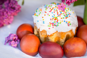 Colored eggs on white textile background, easter cake and white spring hawthorn flowers. Holiday. 