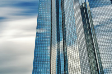 Modern office blocks mirrored windows reflecting the clouds and sky.