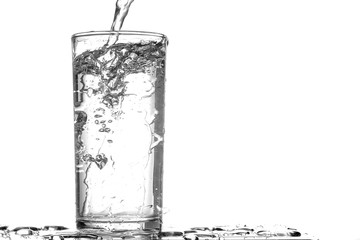 Pouring water into a glass on wooden table with copy space