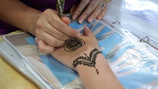 Woman Draws Mehendi on Hands in India
