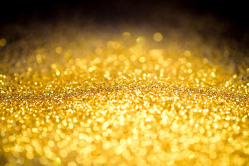 Sprinkle glitter gold dust on a black background ,abstract background texture