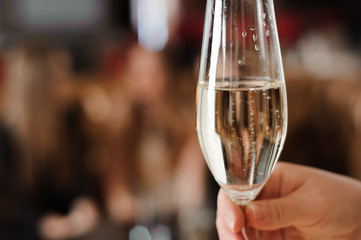 glass of champagne on the background of friends at a party