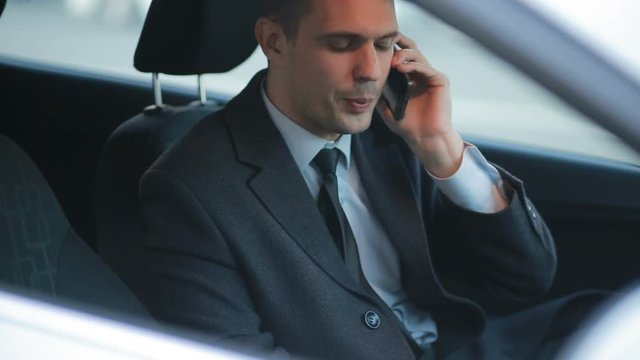 Businessman in car, swearing on the phone.