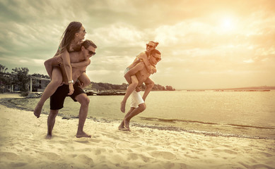 Friends fun on the beach under sunset sunlight.