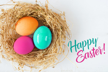 Bright colored dyed eggs on wooden table. Happy Easter eggs card