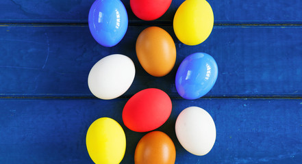 Colored eggs on wooden background, selective focus image. Happy Easter Card - space for text