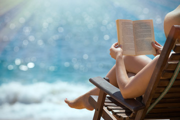 Reading book in the beach hands holding book