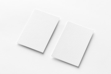 Mockup of two vertical business cards at white textured background.