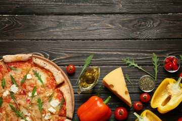Delicious pizza with ingredients on wooden table